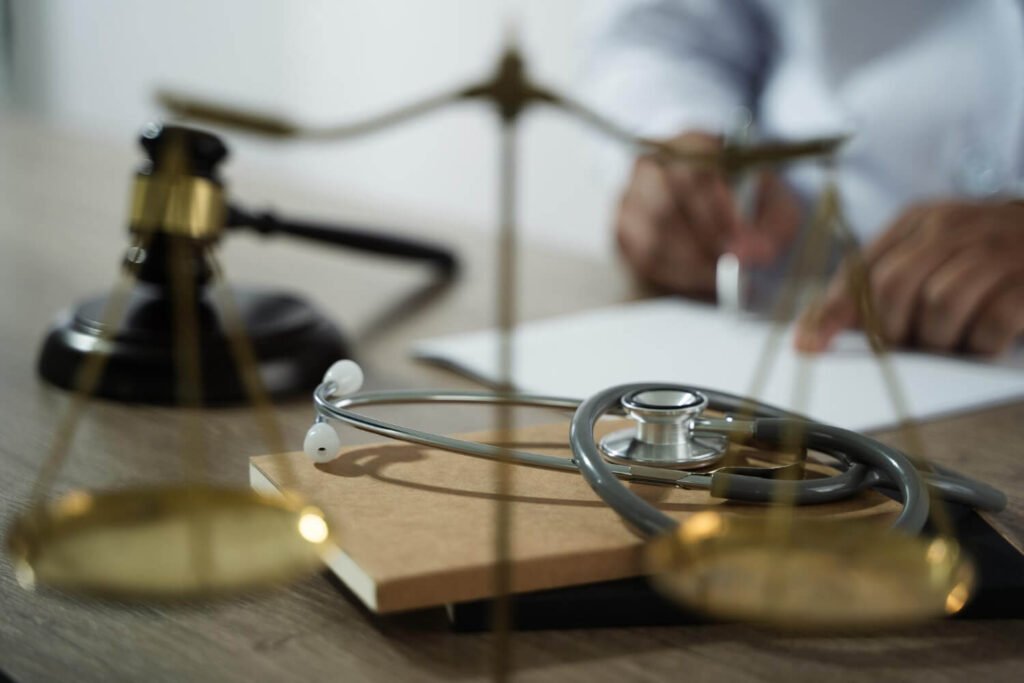 פסל מאזני הצדק לצד סטטוסקופ רפואי - מדריך להגשת תביעות רשלנות רפואית ומימוש זכויות ב-2026.